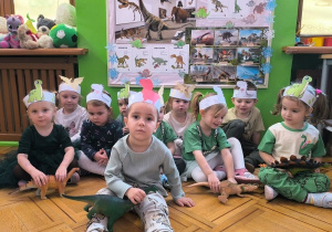 dzieci pozują z modelami dinozaurów