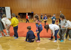 dzieci maszerując w kole grają na instrumentach