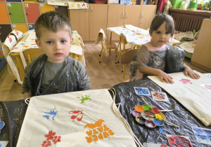 dzieci stemplują wzory na torbach