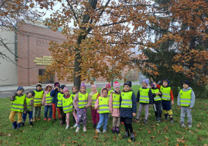 dzieci stoją obok "pomarańczowego" jesiennego drzewa