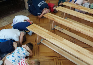 Pani Dzielnicowa razem z dziećmi wykonuje bezpieczna pozycję wobec agresywnego psa