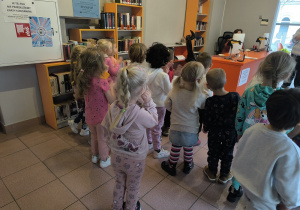 dzieci poznają sposób wypożyczania książek z biblioteki