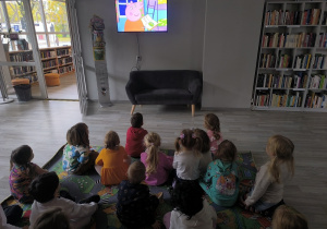 dzieci oglądają bajkę w bibliotece