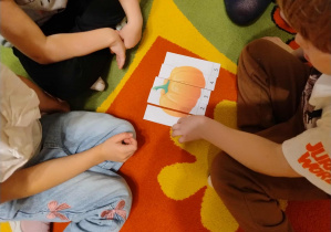 dzieci wspólnie układają obrazek dyni z części