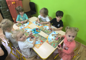 dzieci przyklejają plastelinę do kasztanów