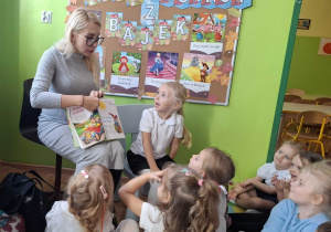 mama Miry pokazuje dzieciom ilustracje w książeczce