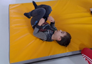 chłopiec ćwiczy na materacu