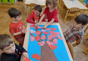 dzieci tworzą drzewo z serduszkami