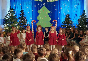 dziewczynki w czerwonych sukienkach tańczą