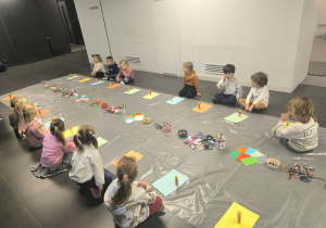 dzieci słuchają instrukcji do pracy plastycznej