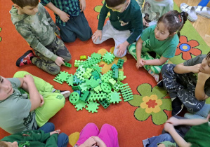dzieci oceniają ilość zebranych na dywanie zielonych klocków