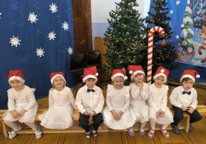 dzieci pozują w czapkach mikołajowych