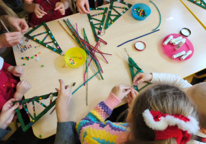 dzieci razem z rodzicami wykonują choinki