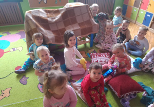 dzieci siedzą na poduszkach