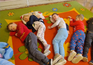 dzieci odpoczywają z pluszakami i poduszkami