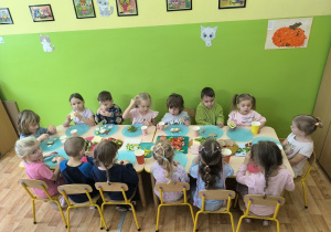 dzieci jedzą przygotowane przez siebie kanapki