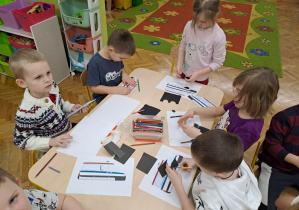 dzieci dorysowują elementy do konturu karetki