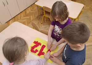 dzieci wyklejają kontur numeru 112