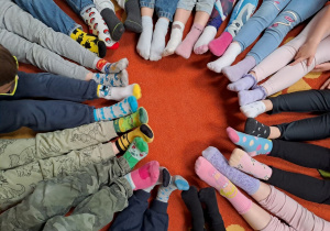 zieci prezentują swoje kolorowe skarpetki nie do pary