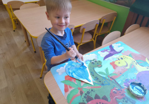 chłopiec maluje farbami