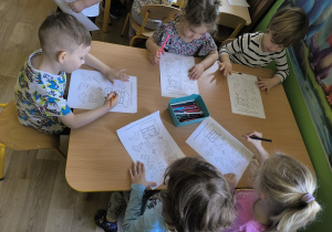 dzieci wykonują zadanie o skarpetkach na karcie pracy