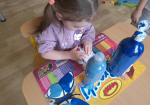 dziewczynka wykonuje pracę - niebieskiego motyla