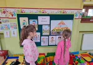 dziewczynki omawiaja poziomy piramidy żywieniowej