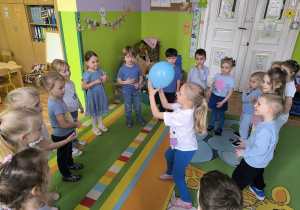 dzieci bawią się niebieskim balonem