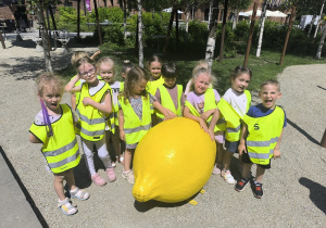 dzieci pozują z rzeźbą cytryny